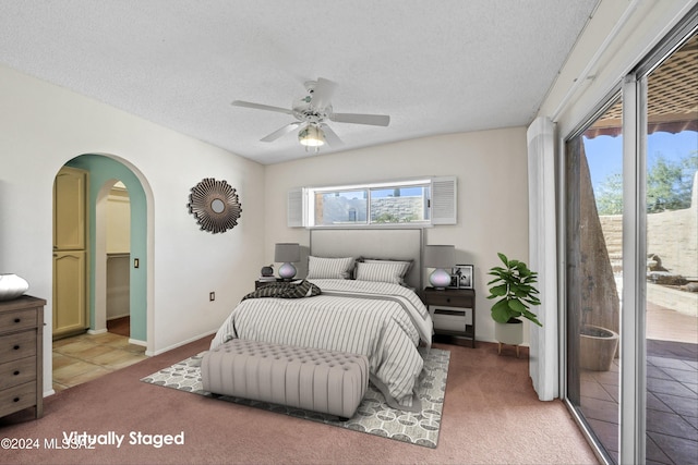 carpeted bedroom featuring access to exterior, a textured ceiling, and ceiling fan