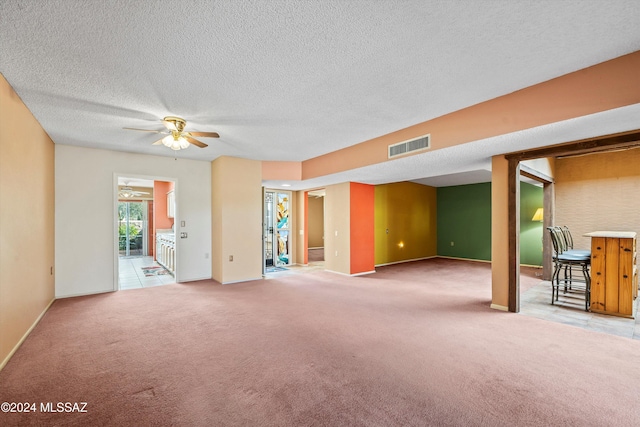 interior space featuring ceiling fan, a textured ceiling, and carpet floors