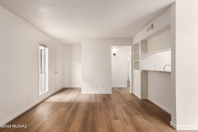 unfurnished room featuring hardwood / wood-style floors and plenty of natural light