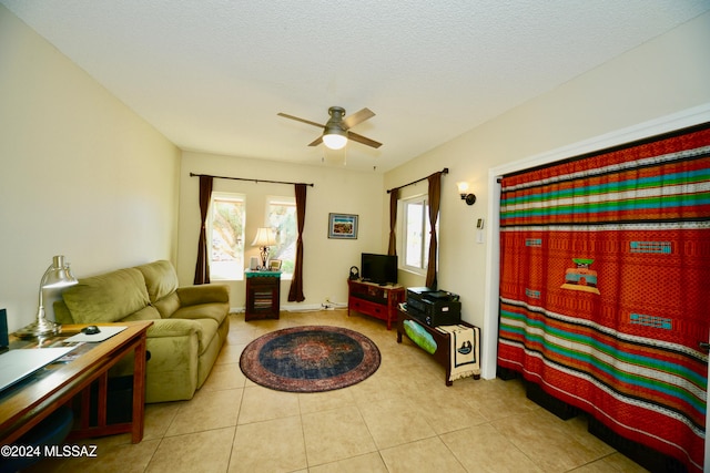 living room featuring a wealth of natural light, ceiling fan, and light tile patterned floors