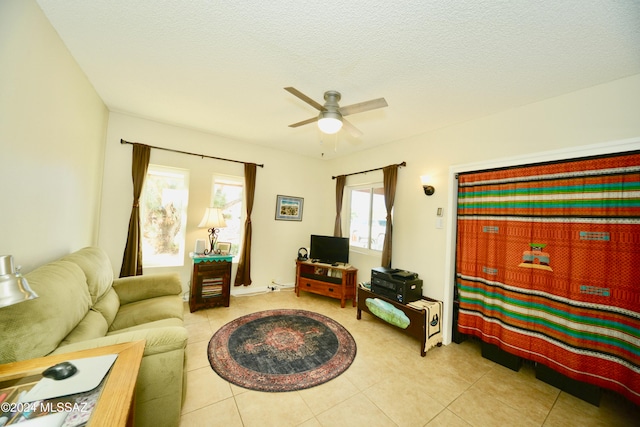 tiled living room featuring ceiling fan and a textured ceiling