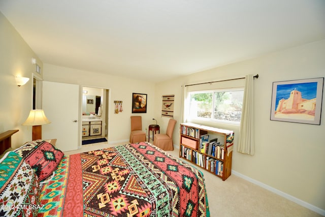 bedroom with ensuite bathroom and carpet floors