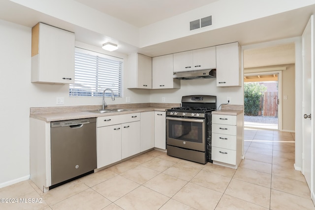 kitchen featuring white cabinetry, sink, light tile patterned floors, and appliances with stainless steel finishes