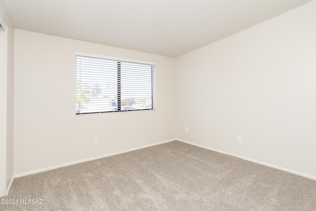 carpeted empty room with a textured ceiling