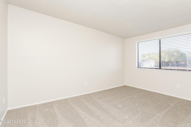 carpeted spare room featuring a textured ceiling