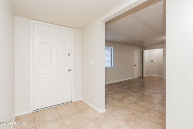 foyer entrance featuring light tile patterned flooring and a textured ceiling