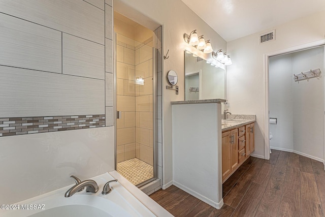 bathroom with vanity, hardwood / wood-style flooring, toilet, and walk in shower