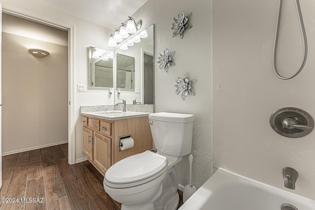 full bathroom featuring wood-type flooring, vanity, washtub / shower combination, and toilet