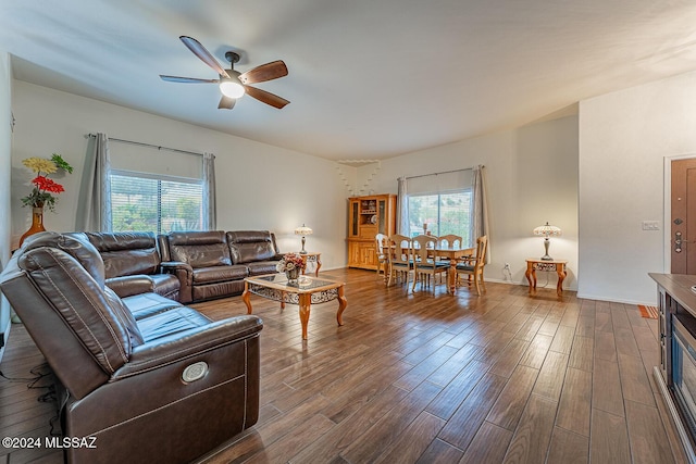 living room featuring ceiling fan, dark hardwood / wood-style floors, and a wealth of natural light