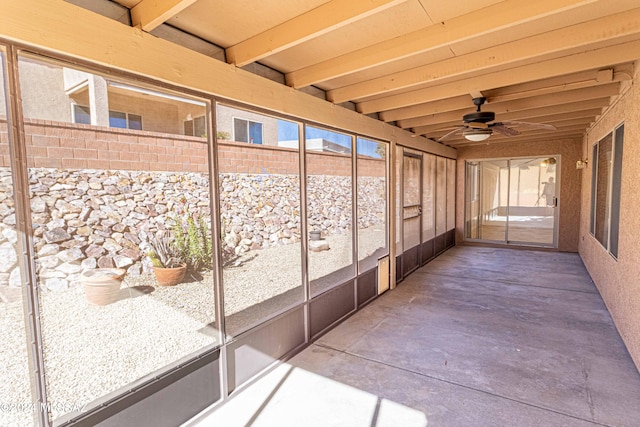 unfurnished sunroom with beamed ceiling and ceiling fan