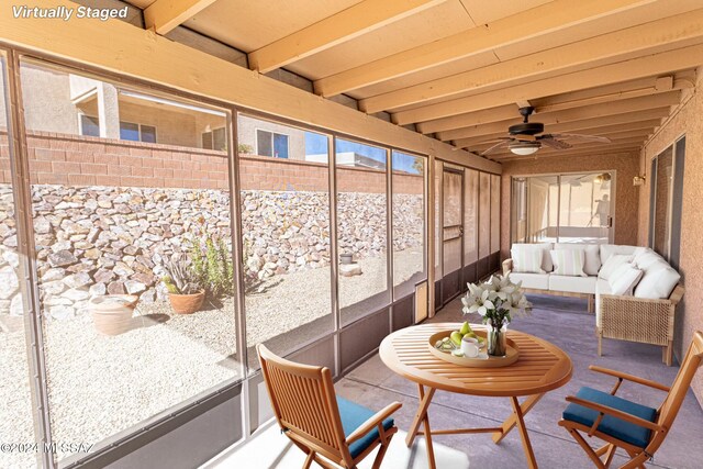 sunroom featuring ceiling fan and beam ceiling