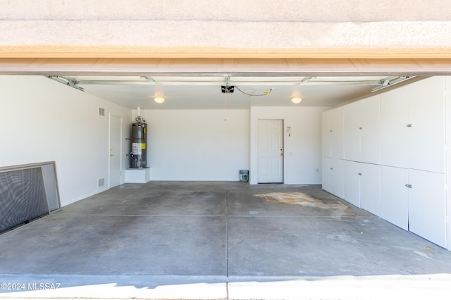 garage featuring strapped water heater and a garage door opener