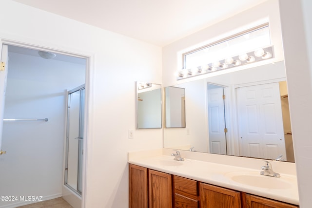 bathroom with vanity and a shower with door