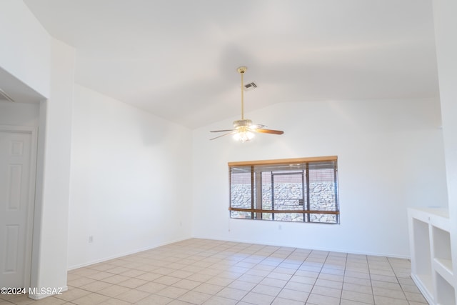 empty room featuring ceiling fan, light tile patterned floors, and vaulted ceiling