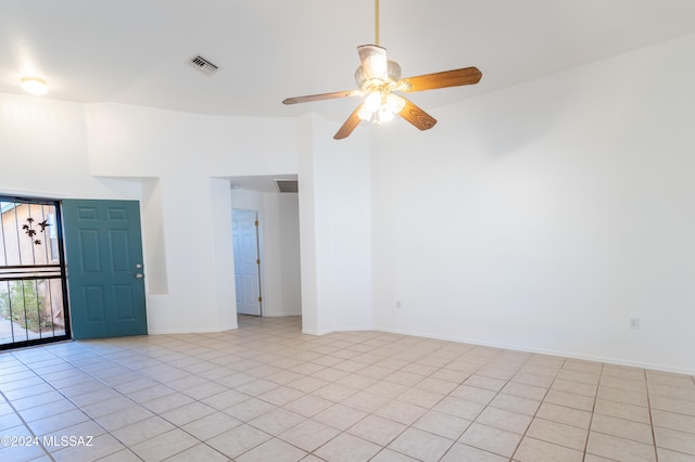 empty room with ceiling fan and light tile patterned floors