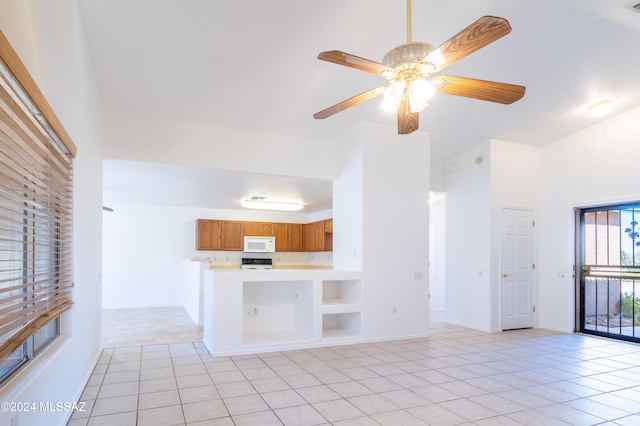 kitchen with kitchen peninsula, light tile patterned floors, white appliances, and ceiling fan