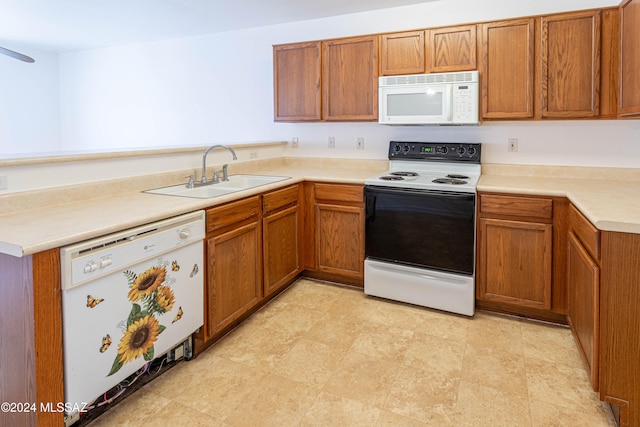 kitchen featuring white appliances, sink, and kitchen peninsula