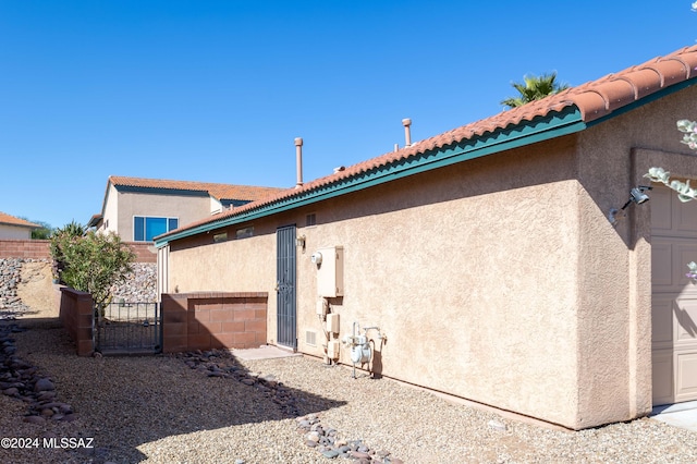 287 N Via Ln, Castellana, Green Valley, AZ 85614 - back of property featuring stucco siding, a gate, and a garage