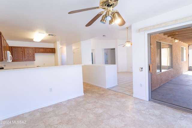 tiled empty room featuring ceiling fan