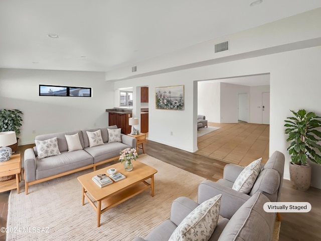 living room with light wood-type flooring and lofted ceiling