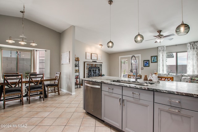 kitchen with stainless steel dishwasher, gray cabinets, lofted ceiling, and sink