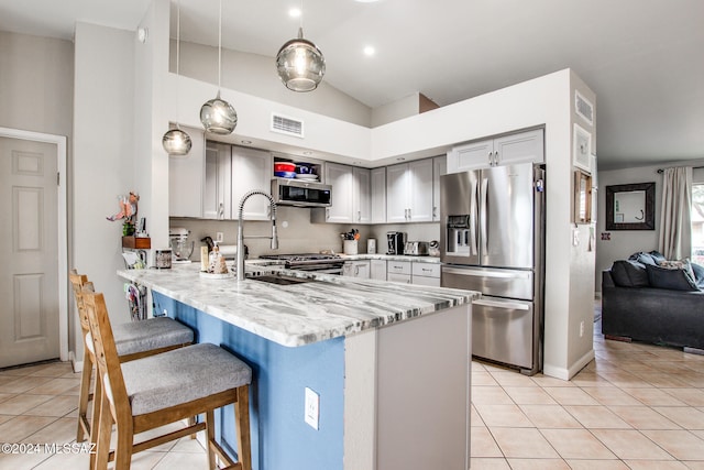 kitchen featuring hanging light fixtures, gray cabinets, light tile patterned floors, kitchen peninsula, and stainless steel appliances