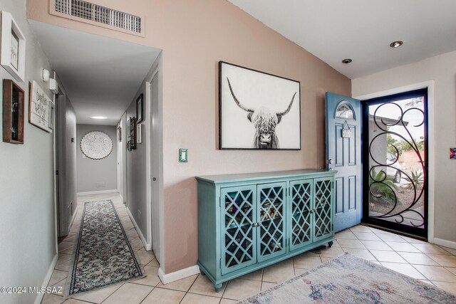 foyer featuring light tile patterned floors and vaulted ceiling