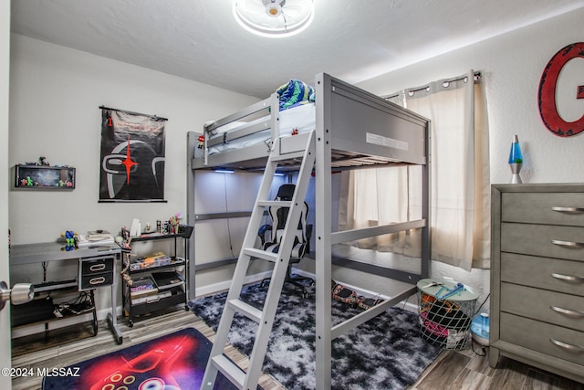 bedroom featuring hardwood / wood-style flooring and a textured ceiling