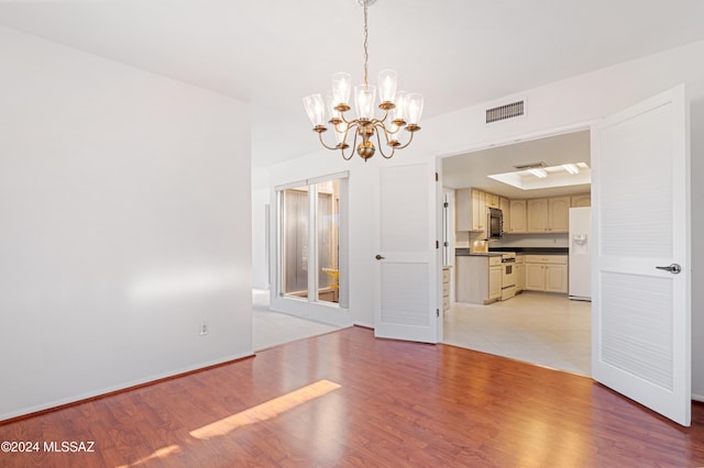 unfurnished dining area with light wood-type flooring and a chandelier