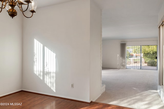 spare room with hardwood / wood-style flooring and a chandelier