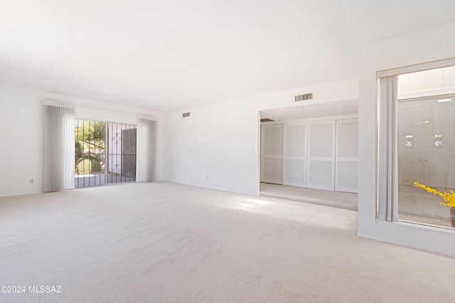 unfurnished room featuring light carpet