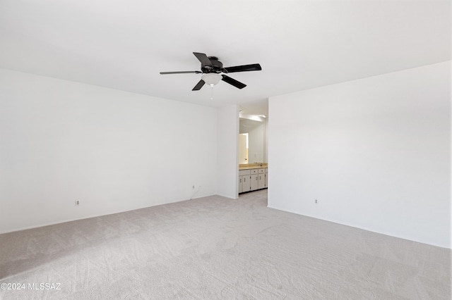 spare room featuring ceiling fan and light colored carpet