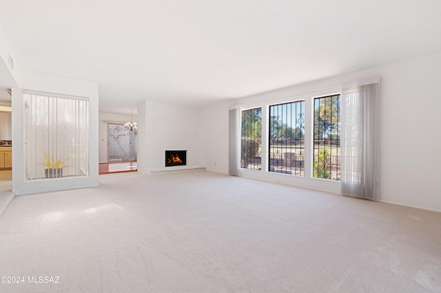 unfurnished living room with a fireplace, carpet floors, and a chandelier