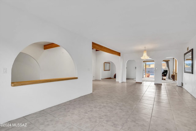 unfurnished living room with a notable chandelier and light tile patterned flooring