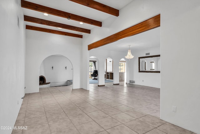 unfurnished living room featuring light tile patterned floors and beam ceiling