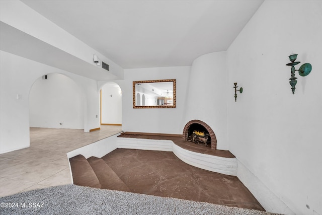 interior space with tile patterned flooring and a brick fireplace