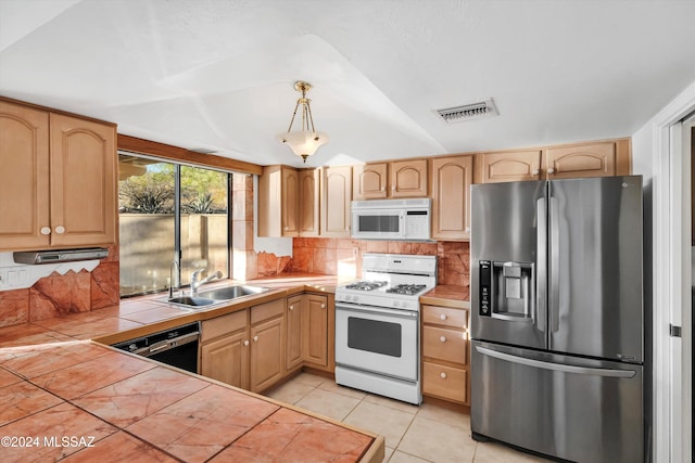 kitchen featuring decorative light fixtures, light brown cabinets, sink, tile countertops, and white appliances