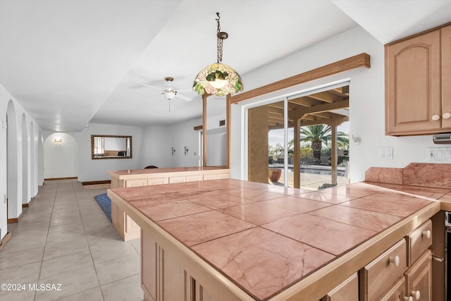 kitchen featuring hanging light fixtures, tile counters, ceiling fan, and light brown cabinets