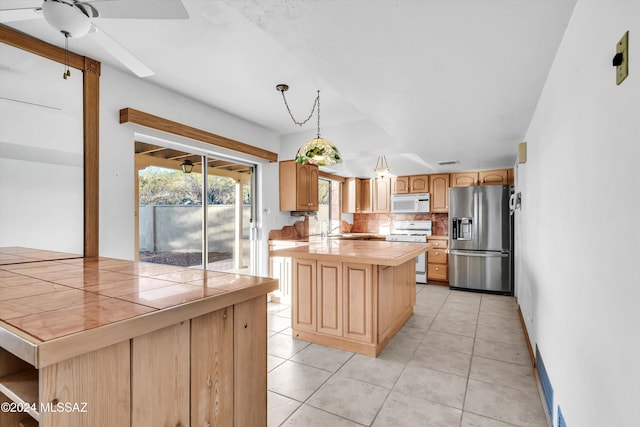 kitchen with tile counters, a center island, and white appliances