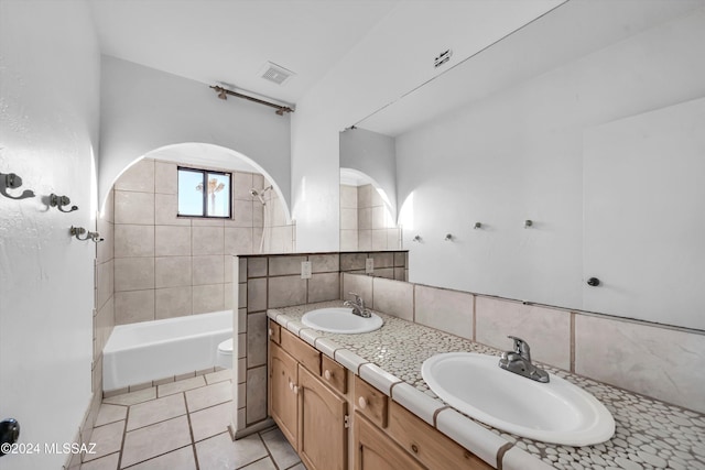 full bathroom featuring vanity, tiled shower / bath combo, decorative backsplash, tile patterned flooring, and toilet