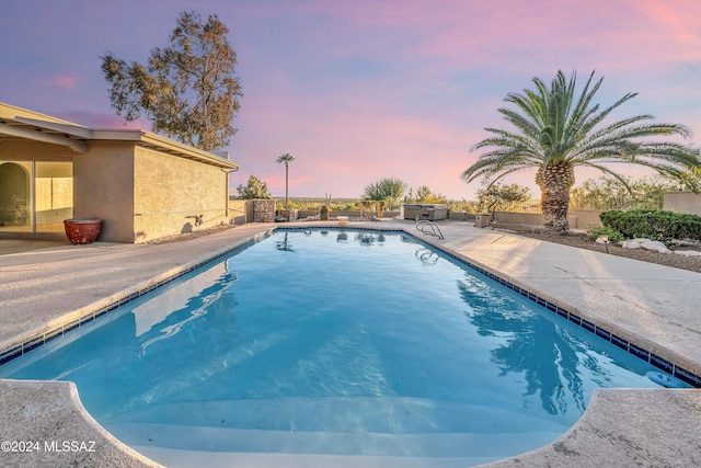 pool at dusk with a patio