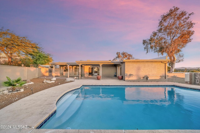 pool at dusk with a patio