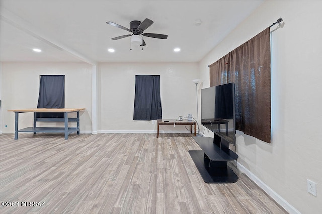 living room with ceiling fan and light wood-type flooring