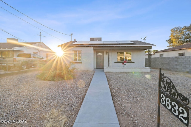 view of front of home featuring solar panels and a porch