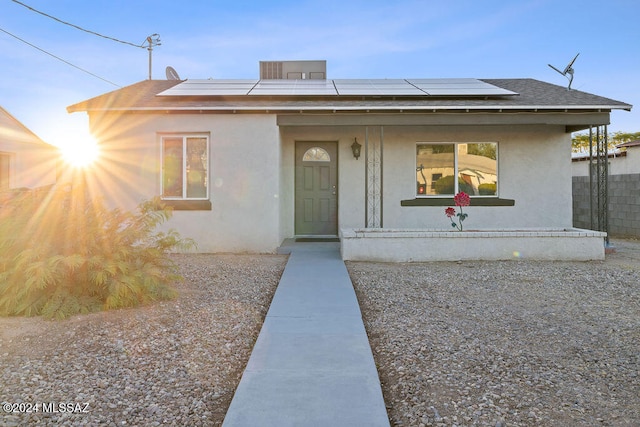 bungalow-style house with a porch and solar panels