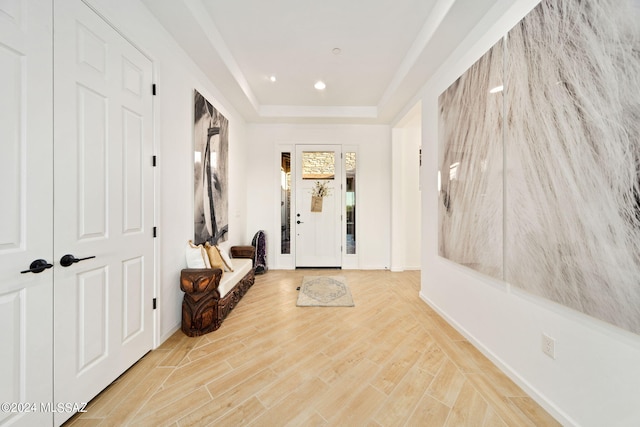 interior space with light wood-type flooring and a raised ceiling