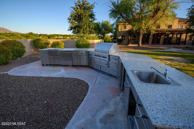 view of patio with area for grilling, sink, and a grill