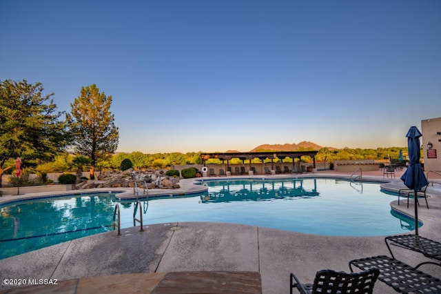 pool at dusk with a patio