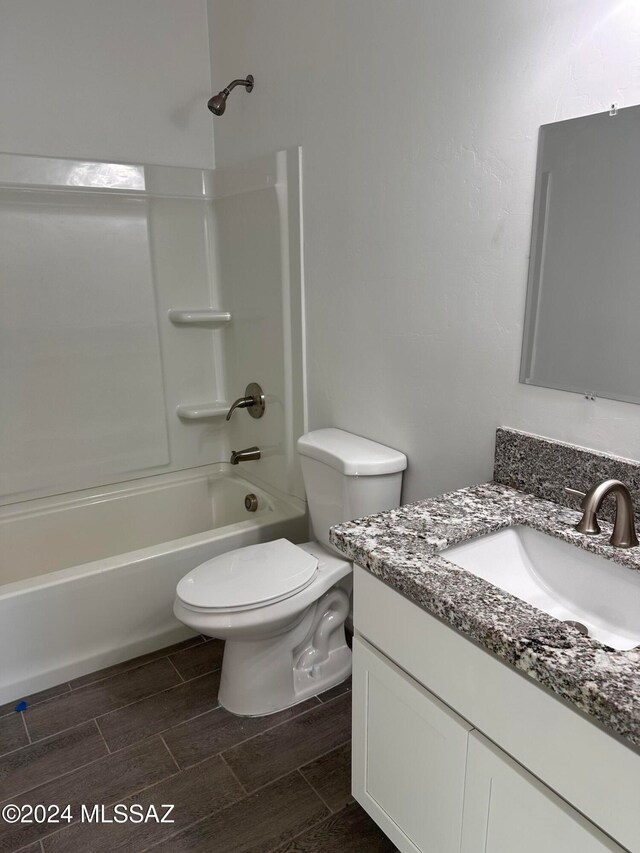 full bathroom featuring washtub / shower combination, vanity, and toilet