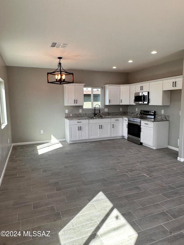 kitchen with stainless steel appliances, dark wood-type flooring, hanging light fixtures, a chandelier, and white cabinetry